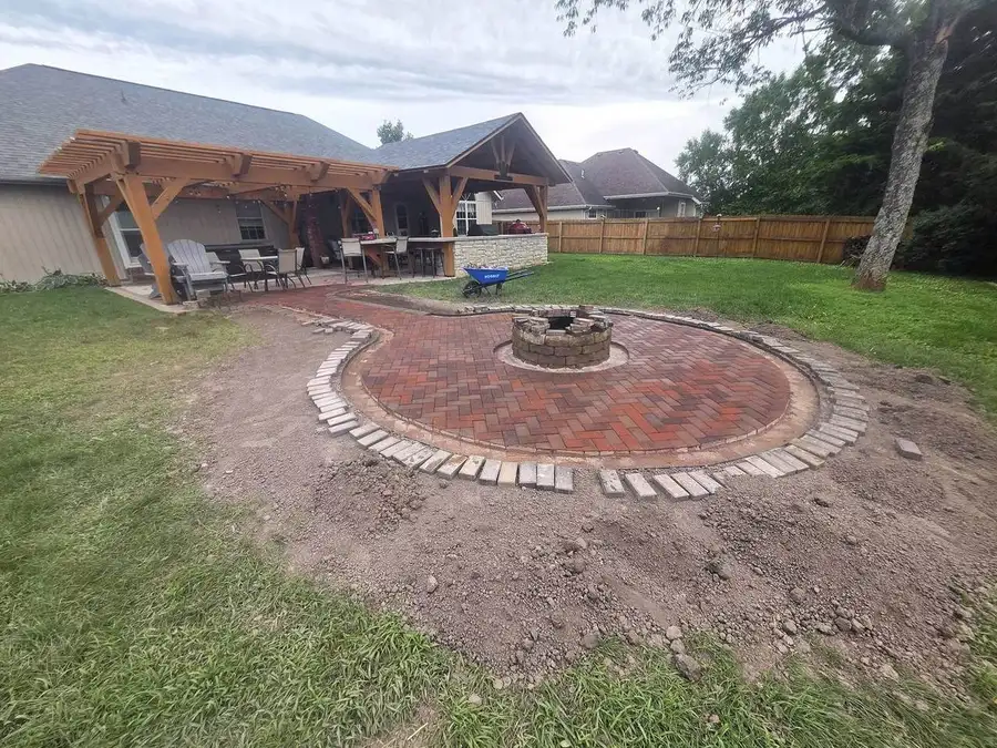 Brick fire pit patio partway built, soldier-course border being set