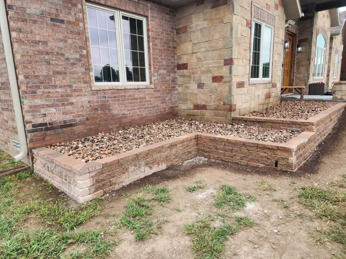 Stone raised bed built against a brick home